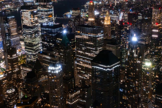 Aerial View of Manhattan Architecture at Night. Evening Shot of Financial Business District from a Helicopter. Scenery of Historic Office Towers, Illuminated Skyscrapers