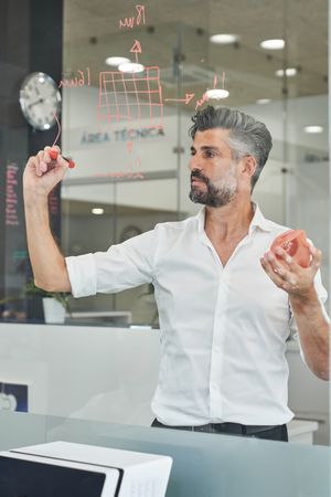 Worker with respirator writing scheme on glass