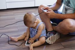 Anonymous father and baby playing video games