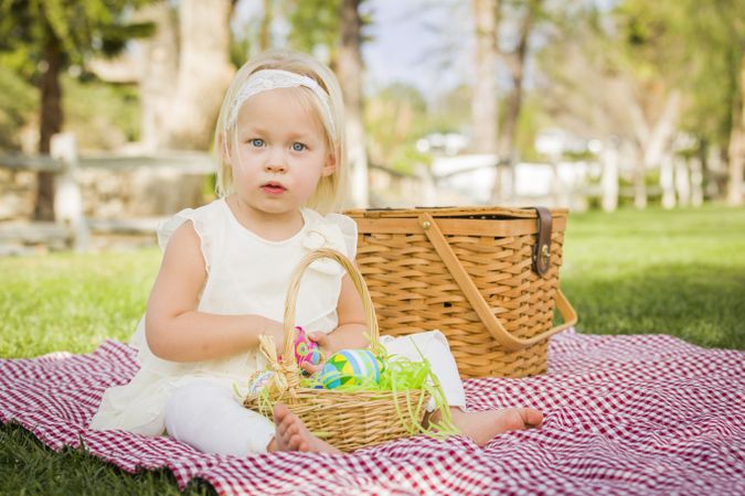 Cute Baby Girl Enjoying Her Easter Eggs on Picnic Blanket
