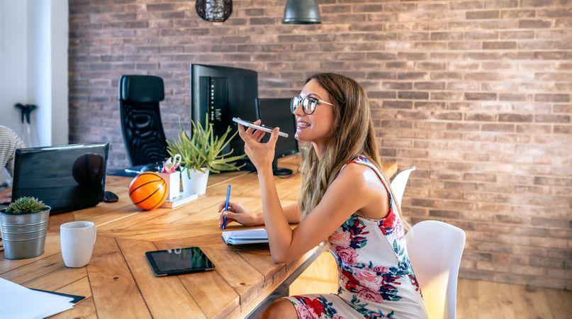 Office worker talking mobile phone with speaker