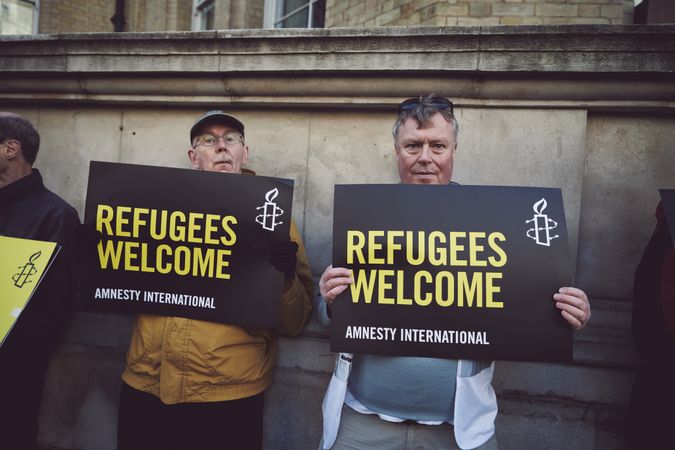 London, England, United Kingdom - March 19 2022: Two men with “Refugees Welcome” signs