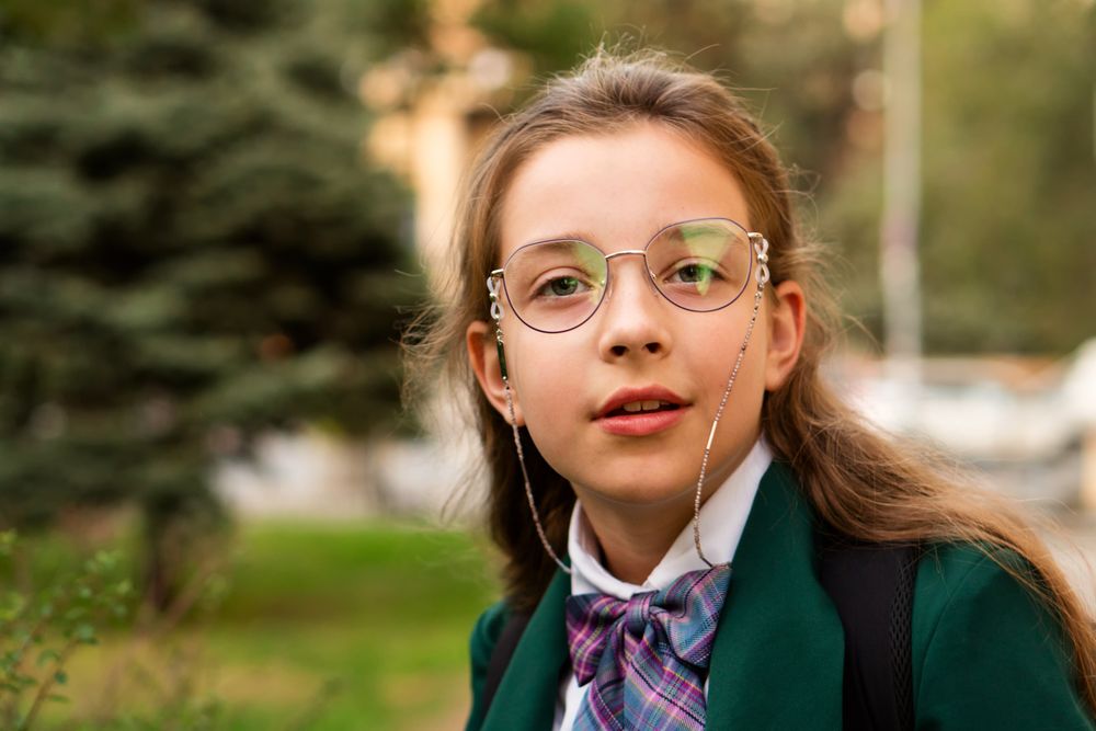 Young girl with glasses and uniform outdoors