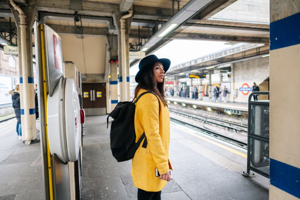 Cheerful woman waiting to catch a train on station