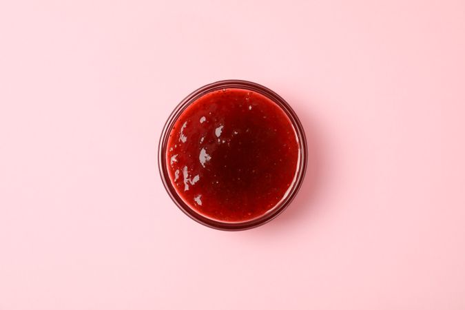 Delicious strawberry jam on pink background, top view