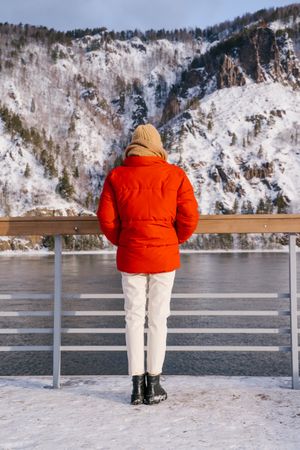 Woman enjoying landscape of river and snowy mountains