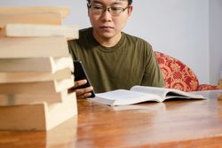 Asian young student study, reading and writing sit on sofa at living room
