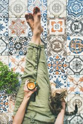 Woman on tiled terrace with coffee and cat