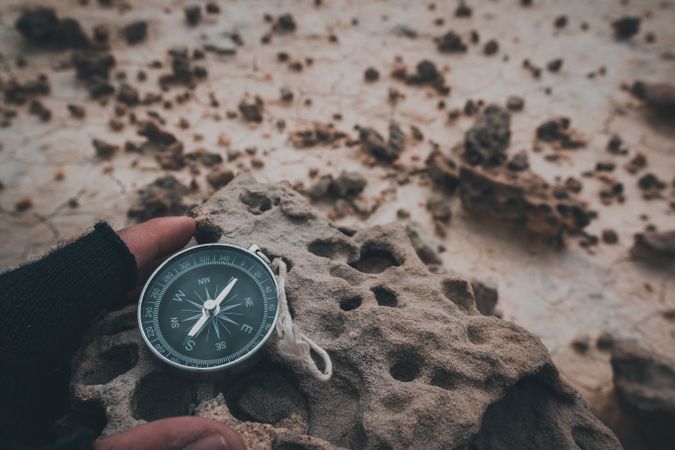 Compass in hand on dry desert area