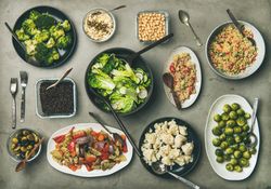 Vegan dinner table setting with healthy vegetarian dishes in plates on table