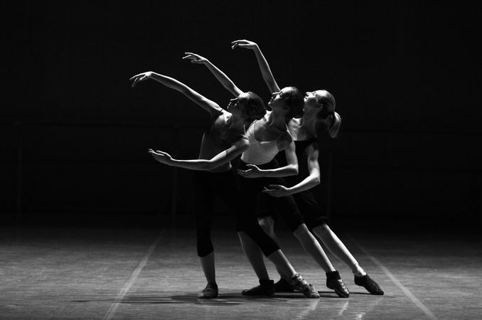 Grayscale photo of three women dancing on stage