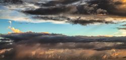 Dark grey clouds with light blue sky peaking through