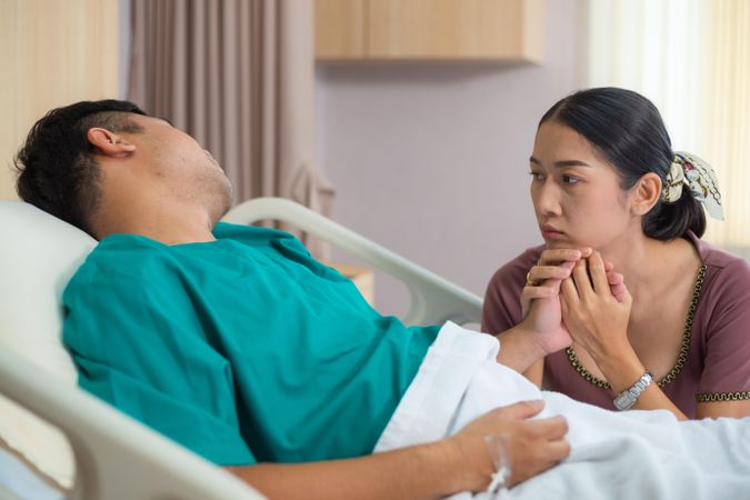 Concerned wife at husband’s hospital bedside
