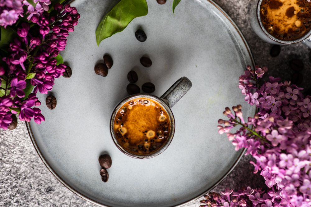 Top view of coffee and lilac flowers