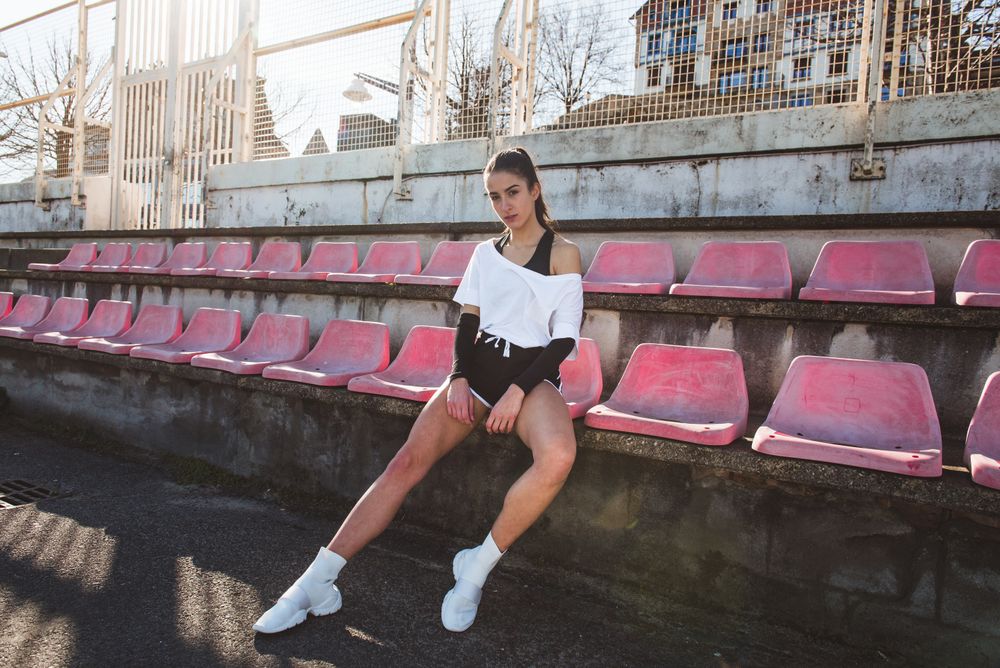 Young sportswoman resting on shabby seat