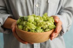 Woman hold bowl with hop, front view