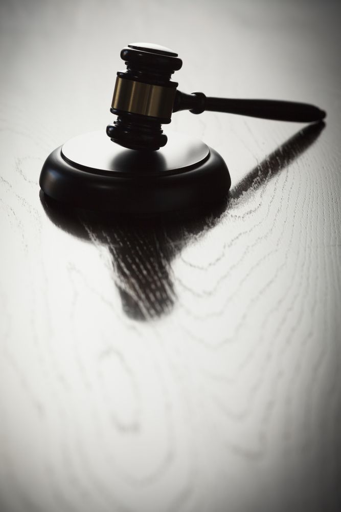 Dramatic Gavel Silhouette on Reflective Wood
