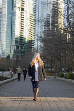 Smiling woman wearing a blazer walking in the city