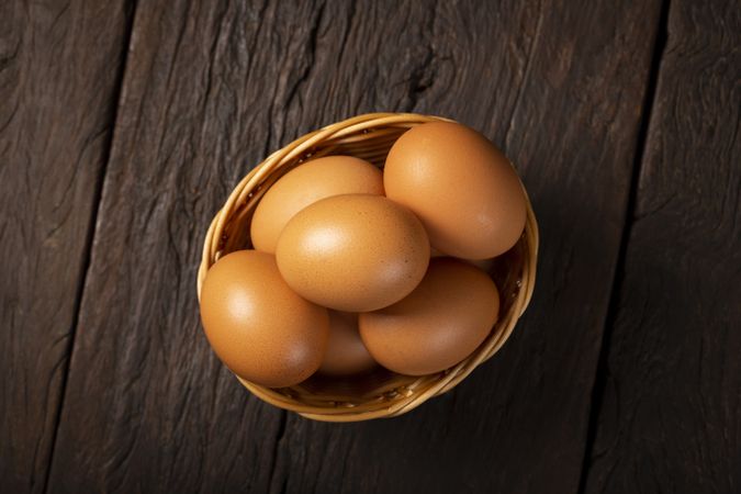 Basket with brown chicken eggs goes up the table.