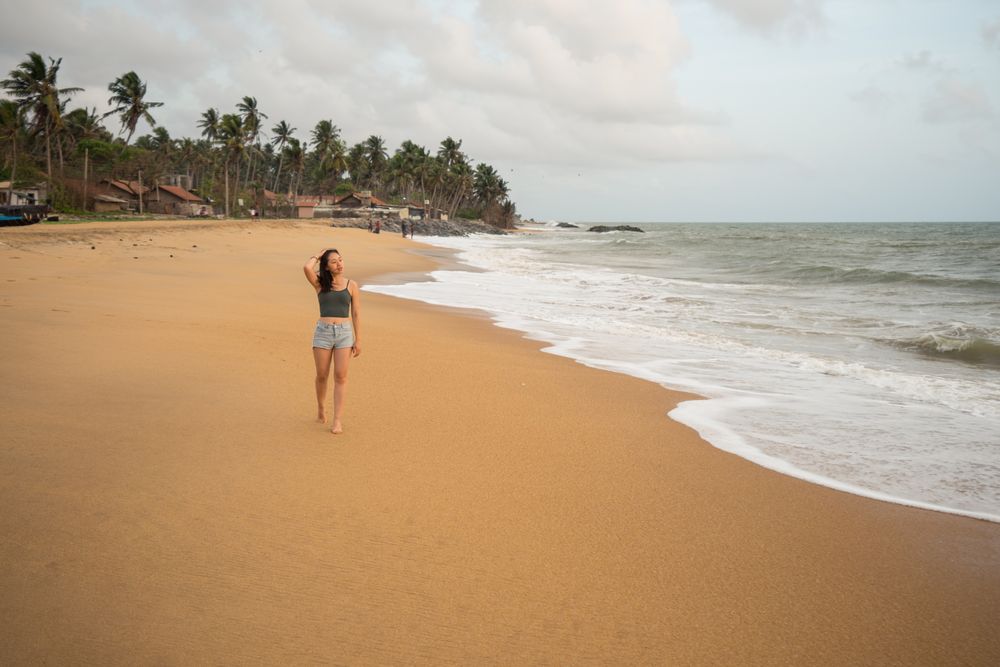 Woman in beachwear walking on sand barefoot