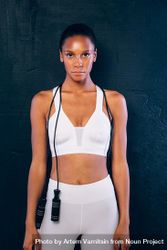 Sporty woman standing tall with a jump rope around neck 5z8Bkb