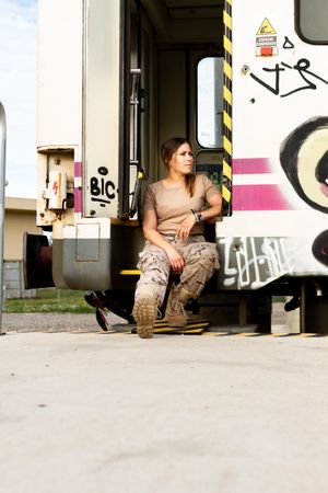 Military woman sitting near van