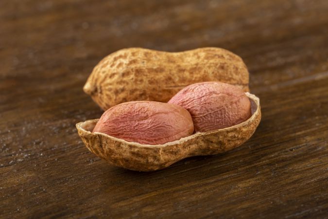 Dry peanut on the wooden background.