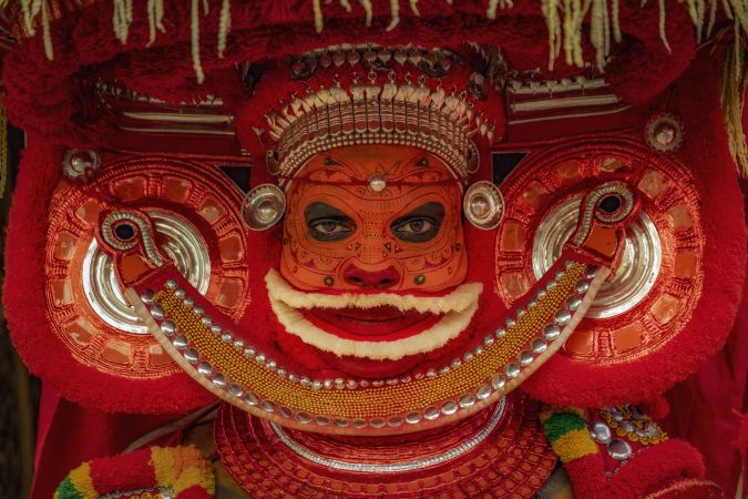 Portrait of an Indian man disguised as Theyyam Hindu deity