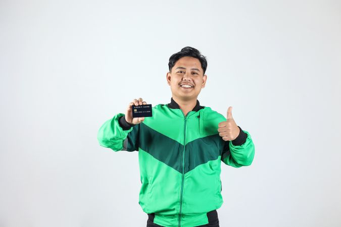 Asian Online Driver Holding Credit Card with Ok Gesture