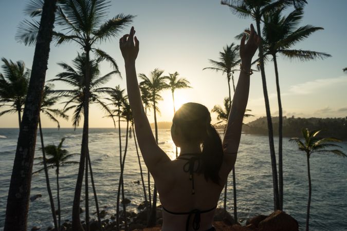 Tranquil female traveler among palms at seashore
