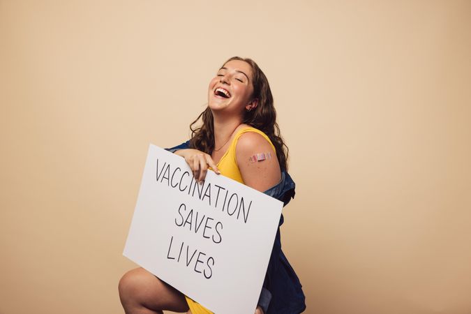 Laughing woman with a banner showing "vaccination saves lives"