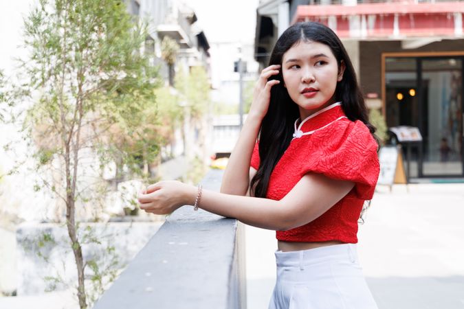 Portrait of woman in red shirt standing in the city