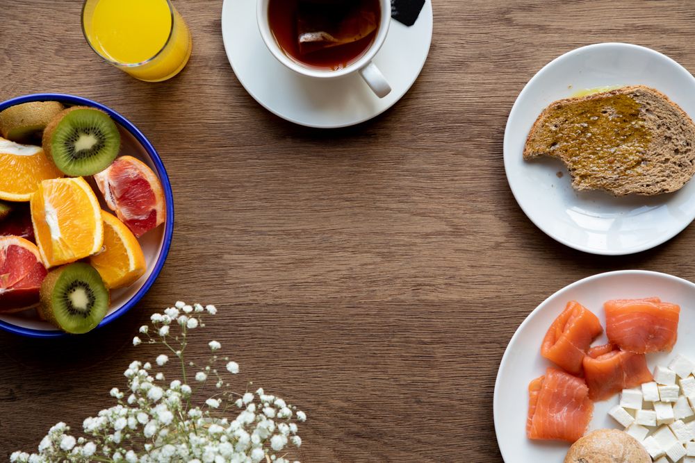 Juice and plate with granola and fruits on table