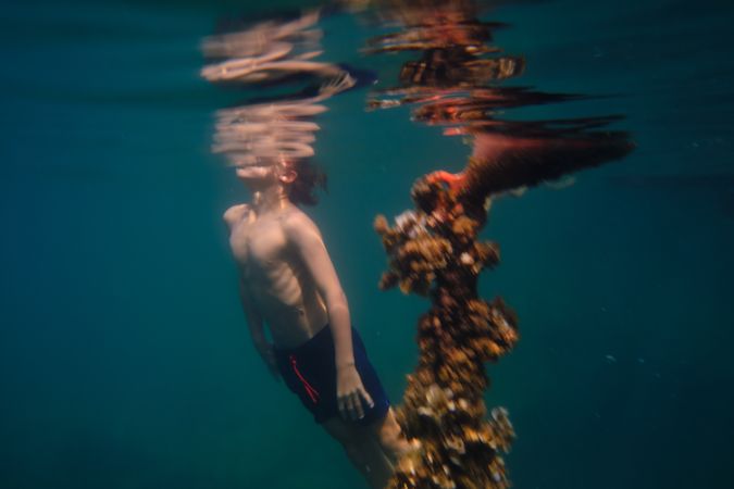 Unrecognizable child swimming underwater