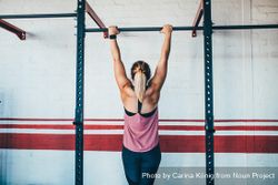 Woman hanging from a bar in the gym k4Mx15