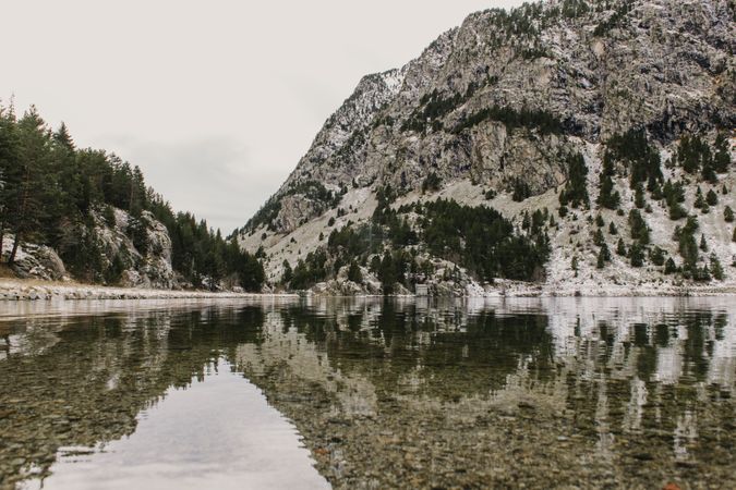 Wonderful lake between hills in snow and cloudy sky