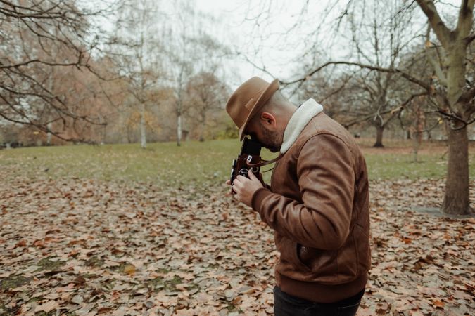 Male photographer standing in autumn park