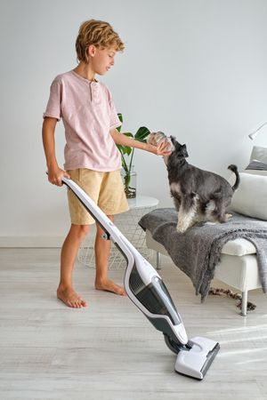 Boy petting dog during housework