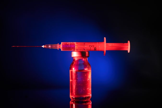 Syringe on top of vaccine ampoule