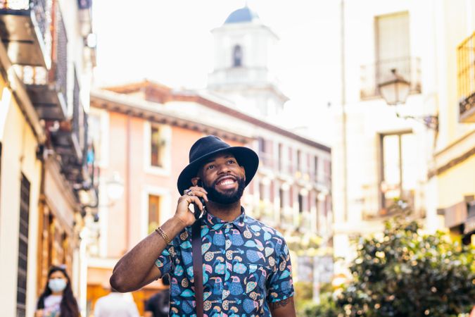 Stylish Black man talking on the phone outdoors in the city