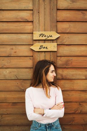 Woman leaning on wooden wall with two signs