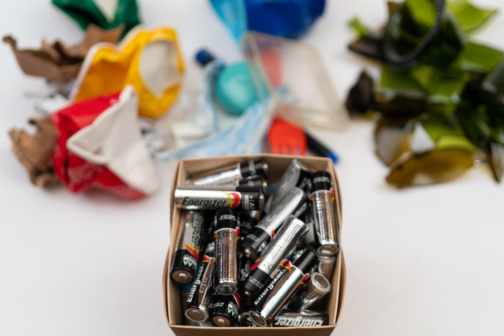 Batteries in a box near sorted trash