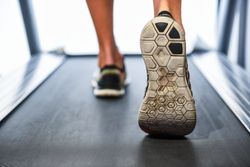 Feet of male on running machine