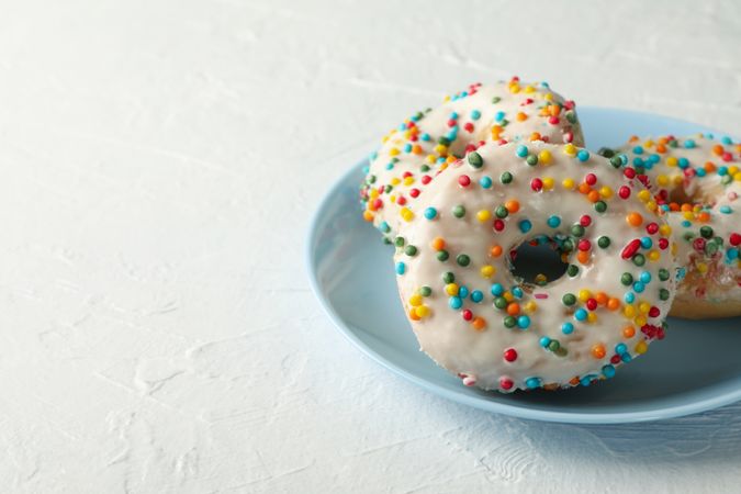 Plate with tasty donuts on plain background