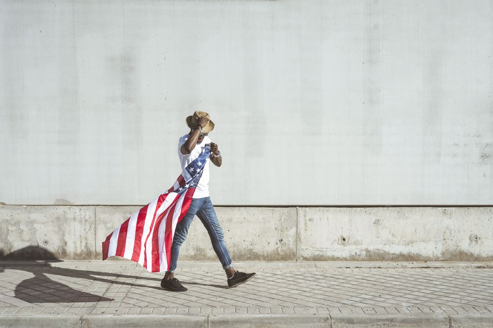 Happy black man with flying American flag