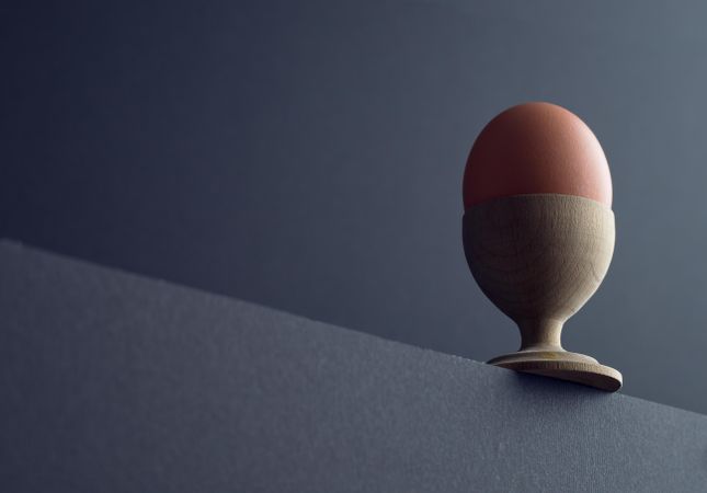 Brown egg in a egg cup at the edge