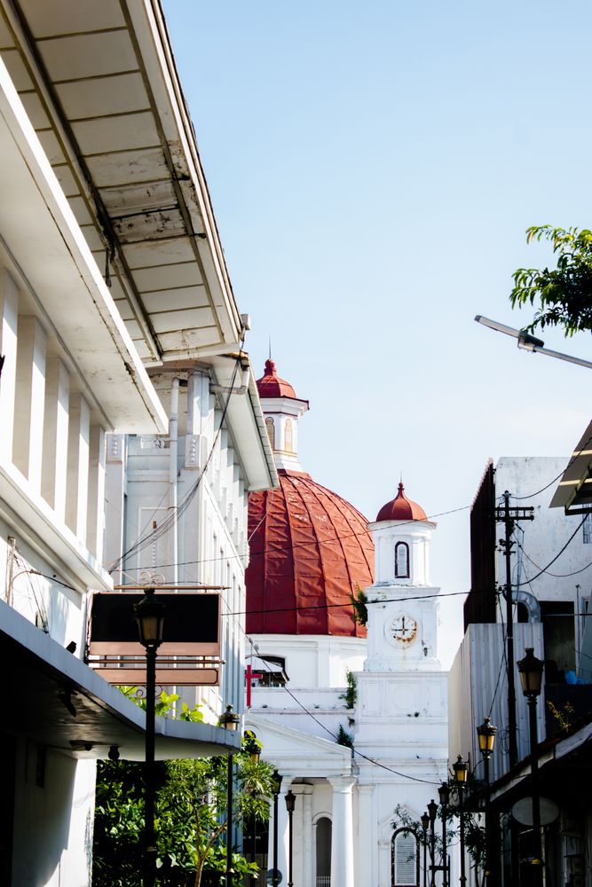 Building and street lamps from street alley of Kota Lama Semarang, Indonesia with background of Church with big red dome