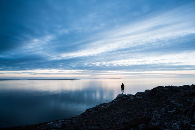 Happy woman on rocky coastline