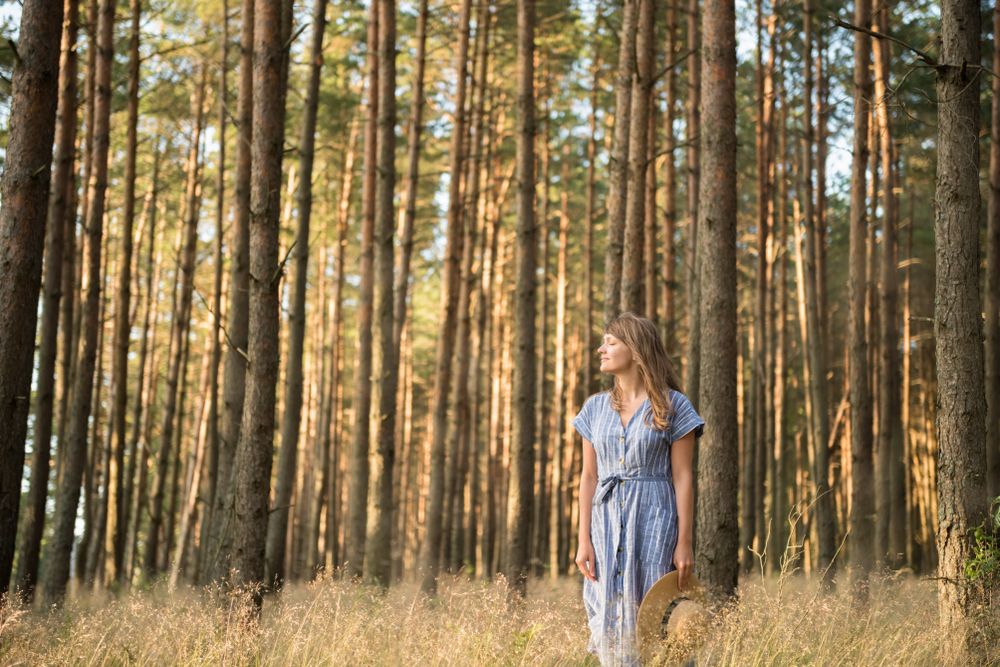 Smiling young woman relaxing among pine trees