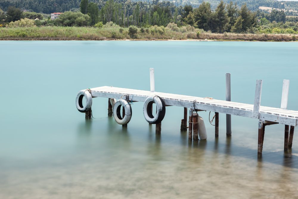 Wooden broken old pier in calm water